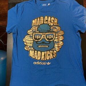 Adidas “Mad Cash Mad Kicks” Blue Tee with Gold Graphic